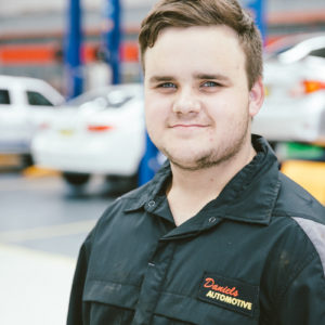 Blake from Daniels Automotive posing for a headshot photo at the workshop